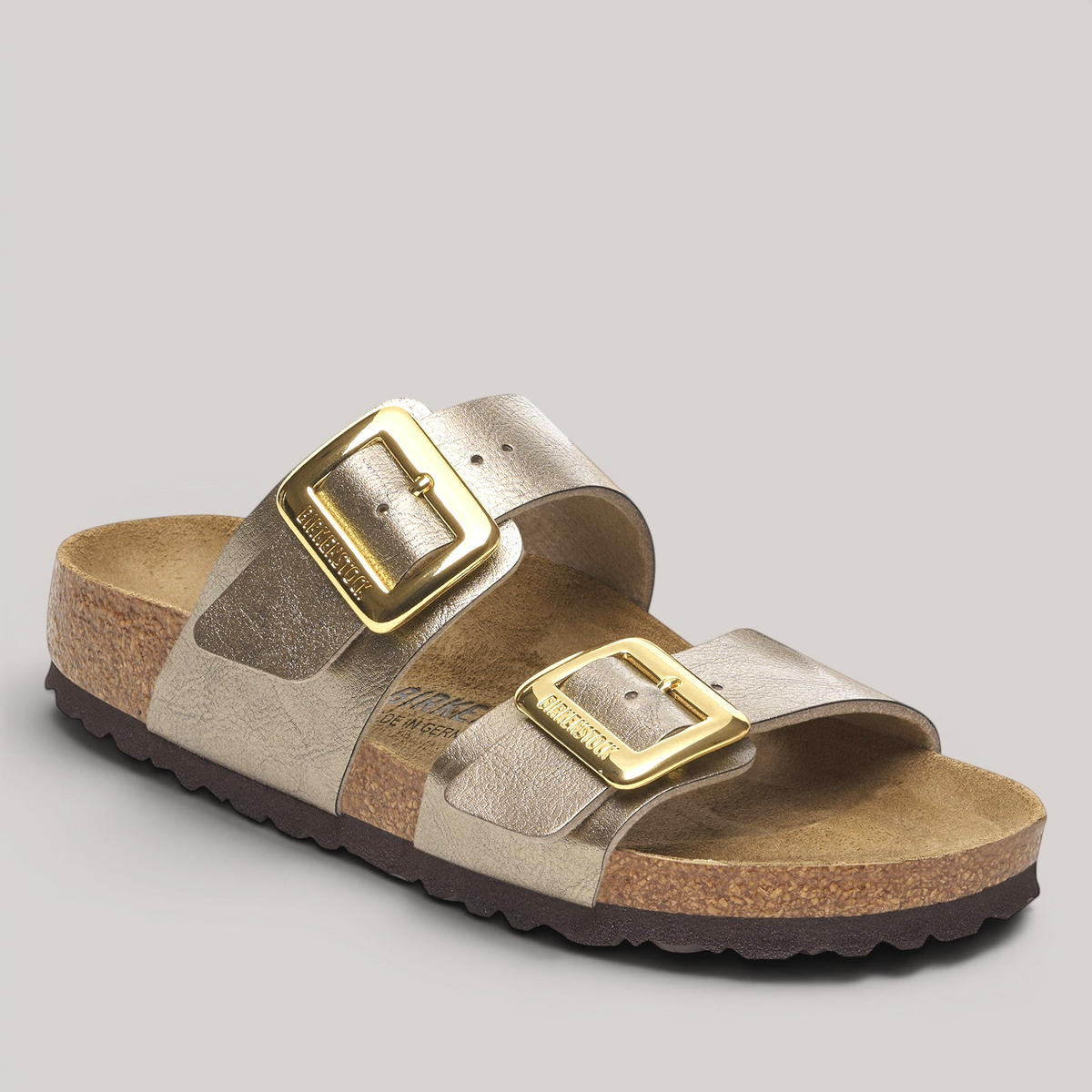 Grundy's Shoes Birkenstock Sydney sandal in metallic gold Birko-Flor with two straps and large gold buckles.