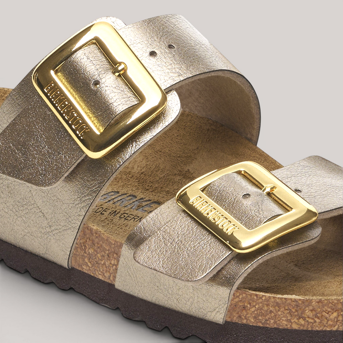 Grundy's Shoes Birkenstock Sydney sandal in metallic gold Birko-Flor with two large polished gold-tone buckles.