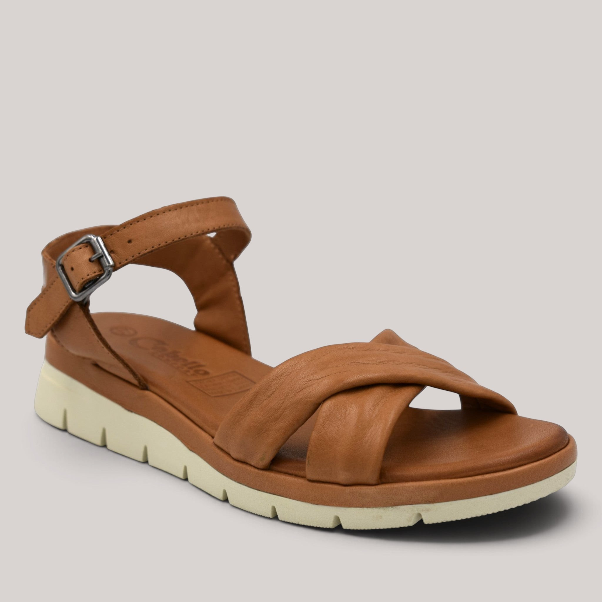 Grundy's Shoes Cabello Able tan leather sandal with crisscross straps, adjustable buckle, and cushioned rubber sole.