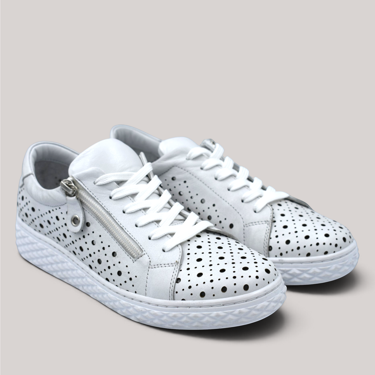 Grundy's Shoes Cabello Uptown white perforated leather sneakers with lace-up closure and side zip for easy access.