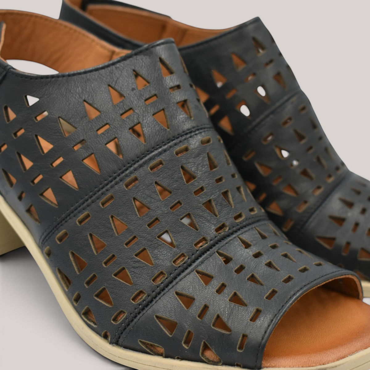 Grundy's Shoes Cabello Wilder black leather sandals with punched triangle patterns, square toe, and heel strap.
