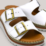 Grundy's Shoes Sala Oasis white leather sandals with adjustable straps, brass buckles, and cushioned platform sole.