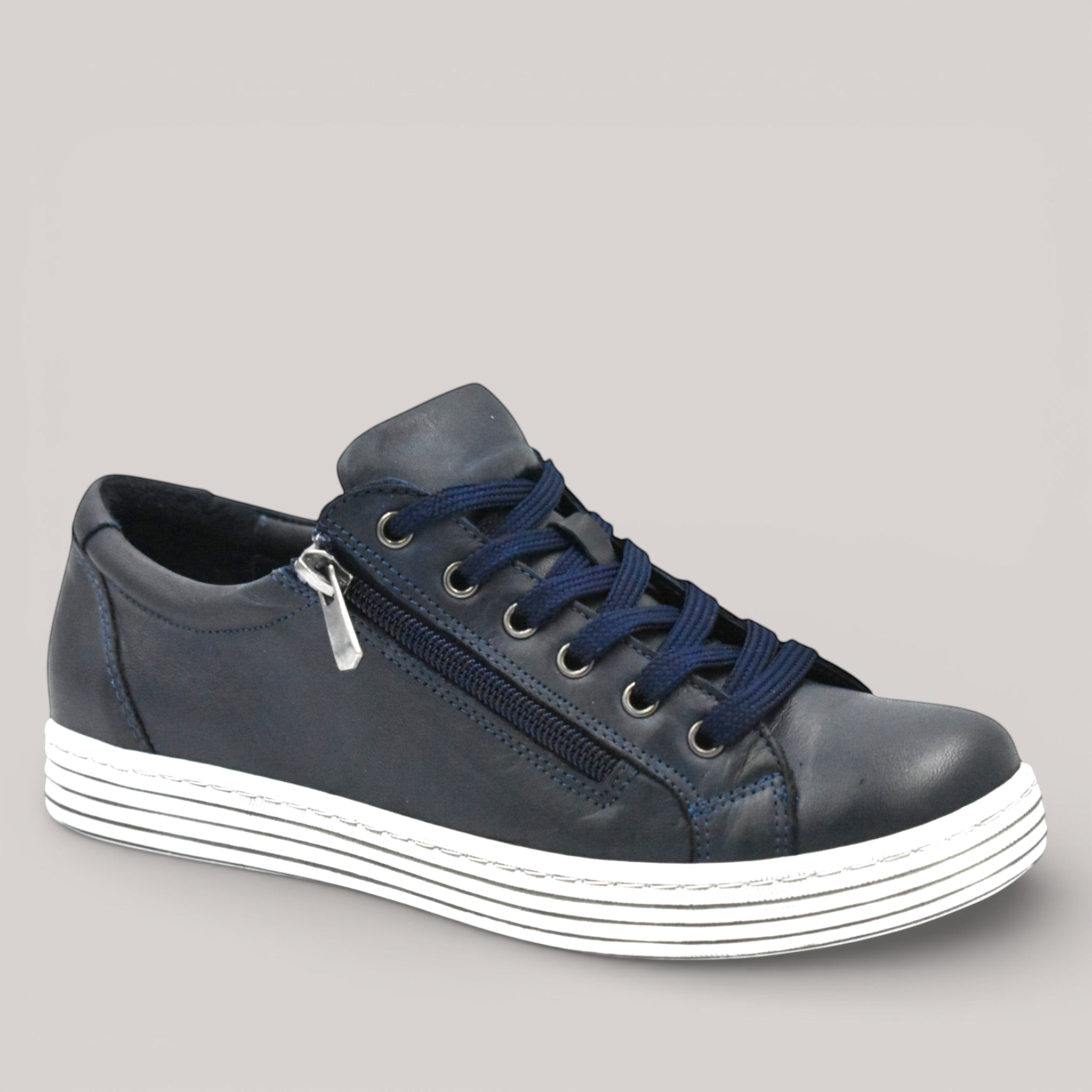 Grundy's Shoes Cabello Unity navy leather sneaker with side zip, adjustable laces, and white striped rubber sole.