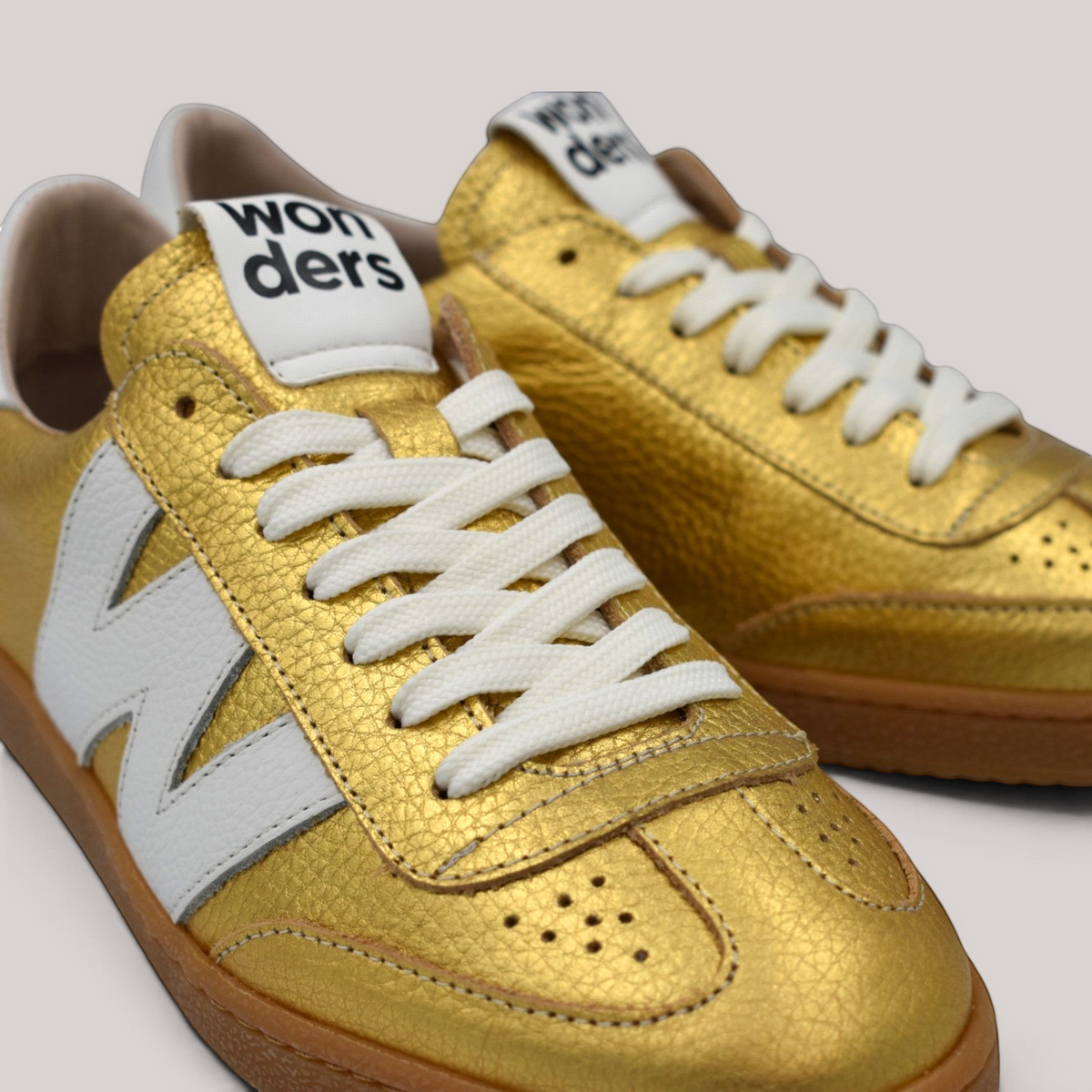 Grundy's Shoes Wonders 2001 gold textured leather sneakers with white laces, logo detail, and caramel rubber sole.