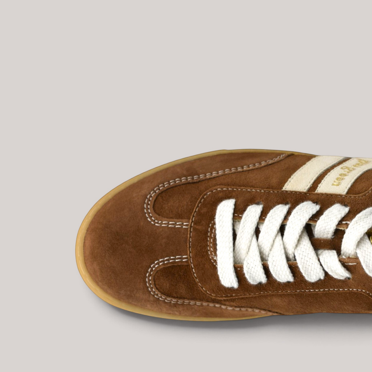 Grundy's Shoes Paul Green 5450 brown suede sneaker with white laces and gum sole, top-down view.